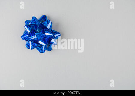 Blue bow festive sur fond de papier gris, overhead view Banque D'Images