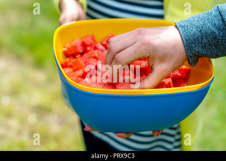 Une femme sur une chaude journée propose des tranches de morceaux de pastèque. Banque D'Images