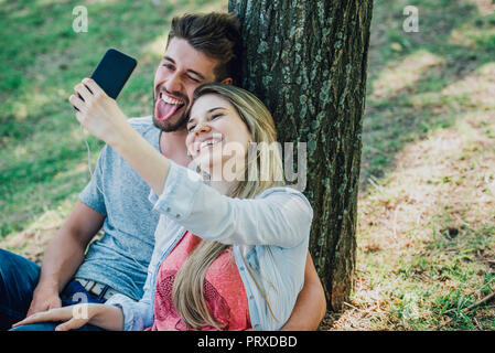 Jeune couple d'écouter de la musique et avec un smartphone selfies Banque D'Images