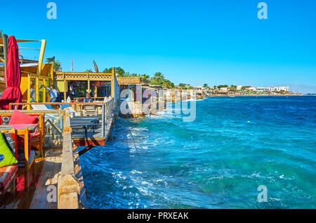 DAHAB, EGYPTE - le 25 décembre 2017 : l'été, terrasses de café côtières fait face à des eaux bleu azur de golfe d'Aqaba, le 25 décembre à Dahab. Banque D'Images