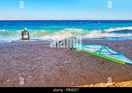 DAHAB, EGYPTE - le 25 décembre 2017 : la planche à vous détendre sur la plage après une longue formation dans le golfe d'Aqaba orageux, le 25 décembre à Dahab. Banque D'Images