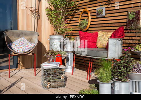 Petit espace balcon jardin avec coussins de banc de jardin en métal réaffecté récipients en métal inhabituels sempervivum succulent plantes succulentes afficher UK Banque D'Images