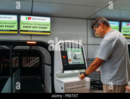 L'aéroport de Lisbonne, Portugal - Oct 3, 2018 : utilise un robinet self service check-in pour ses bagages à l'aéroport Banque D'Images