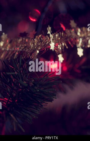 Arbre de Noël décoré et une vue en gros plan d'étoiles d'or sur tons scintillants, effet rétro. Banque D'Images