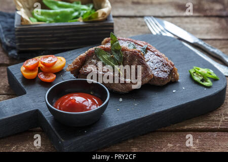 Picanha viande steak, traditionnel brésilien couper sur une planche à découper noire Banque D'Images