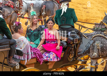 Séville, Espagne - 15 Avril 2018 : les jeunes femmes portant des robes ou des robes sévillane flamenca dans une calèche en Avril de Séville Fai Banque D'Images
