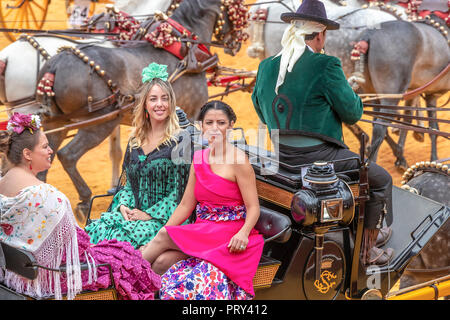Séville, Espagne - 15 Avril 2018 : les jeunes femmes portant des robes ou des robes sévillane flamenca dans une calèche en Avril de Séville Fai Banque D'Images
