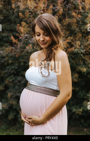 Portrait of pregnant woman holding her belly Banque D'Images