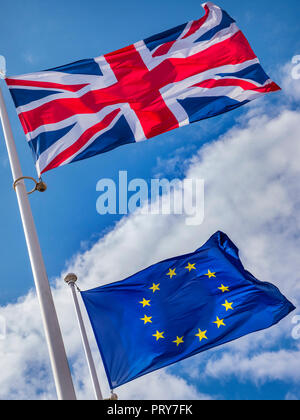 BREXIT CONCEPT DRAPEAUX UK Union Jack Flag vol au-dessus de l'Union européenne Drapeau dans une forte brise sur une journée ensoleillée avec ciel bleu et drapeaux divisé par les nuages Banque D'Images