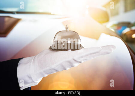 Close-up of a person's Hand Holding Bell Service en face de voiture Banque D'Images