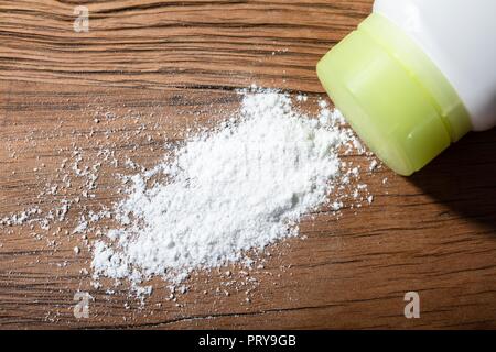 Close-up du produit répandu de la poudre de talc sur le bureau en bois Banque D'Images