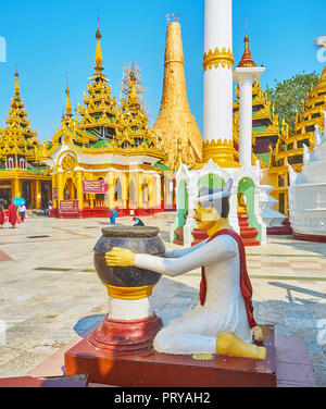 YANGON, MYANMAR - février 27, 2018 : l'autel de pierre et la statue d'un homme dans le sanctuaire sur le territoire de Shwedagon Zedi Daw complexe, sur le mois de février Banque D'Images
