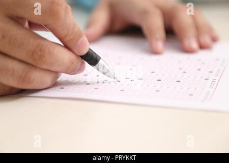 Photo de l'homme est de remplir la fiche de lecture OMR avec stylo. Banque D'Images