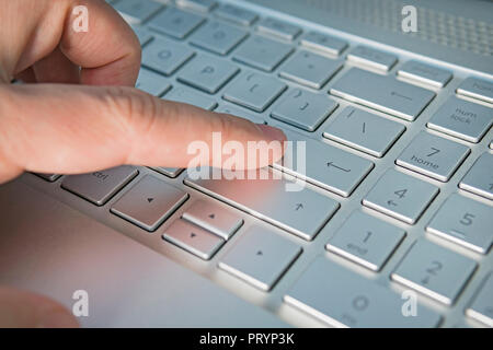 Close-up de main d'hommes tapant. gris argent bouton clavier close up, doigt appuie sur le bouton Entrée. Langue anglaise et voyant rouge pour hack clavier Banque D'Images