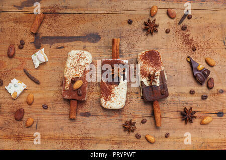 Des espresso et chocolat blanc sucettes glacées avec des épices d'hiver sur fond de bois Banque D'Images