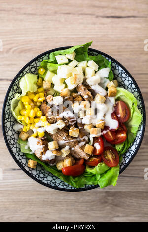 Bol de salade césar avec la viande, le maïs et les tomates Banque D'Images