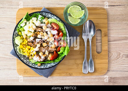 Bol de salade césar avec la viande, le maïs et les tomates Banque D'Images