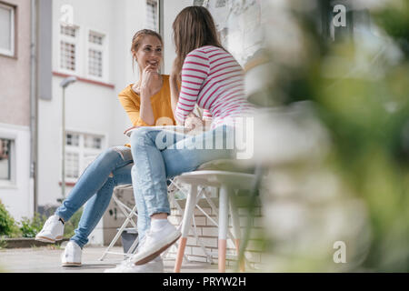 Réunion de deux copines dans un café, parler Banque D'Images