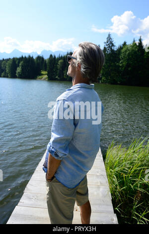 Allemagne, Mittenwald, mature man standing on jetty at lake relaxing Banque D'Images