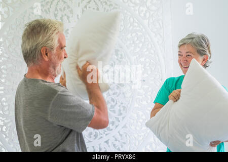 Couple heureux de l'homme et de la femme peuples caucasiens adulte âge jouer à la maison dans la chambre à coucher avec oreiller war ayant beaucoup de plaisir avec le sourire et rire t Banque D'Images