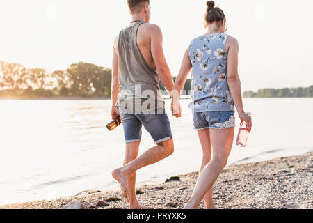 Jeune couple en train de marcher sur la rive Banque D'Images