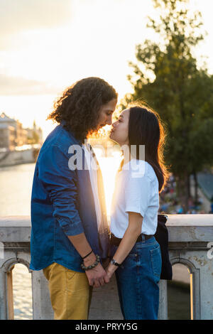 France, Paris, young couple at River Seine au coucher du soleil Banque D'Images