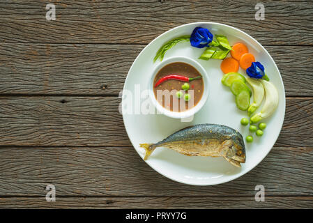 Le Maquereau frit avec sauce chili pâte de crevettes et de légumes frais sur la table en bois Banque D'Images