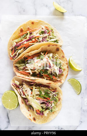 Les tacos de guacamole et servis avec salade de tranches de lime sur un fond clair. Banque D'Images