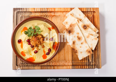 Satsivi à la sauce dinde et aux noix - cuisine géorgienne/arménienne traditionnelle. Servi dans un bol sur une planche de bois avec des tranches de pain plat. Banque D'Images