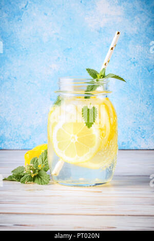 Cocktail pot de limonade et de feuilles de menthe sur fond bleu table en bois de l'eau naturelle de citron sont populaires en verre de boissons detox infusion d'antioxydants. Banque D'Images