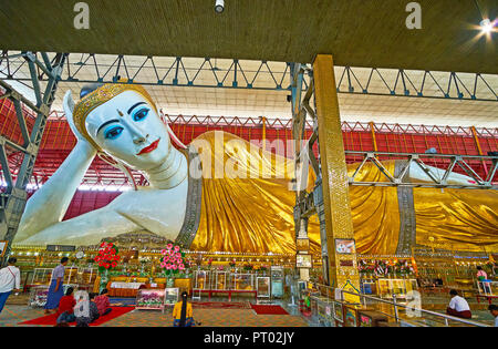 YANGON, MYANMAR - février 27, 2018 : l'image du Bouddha couché en robe dorée, décorée avec des mirrorwork, dans le Temple du Bouddha, Chaukhtatgyi sur Februa Banque D'Images