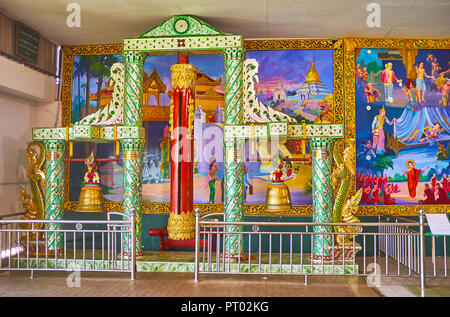 YANGON, MYANMAR - février 27, 2018 : les cloches, décorées avec miroir panoramique au mur coloré avec des peintures murales à Chaukhtatgyi, Temple du Bouddha d'o Banque D'Images