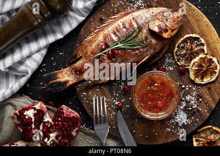 Rougets grillés sur une planche en bois avec du citron et de grenat. Concept de saine alimentation. Vue d'en haut. La vie encore. Mise à plat Banque D'Images