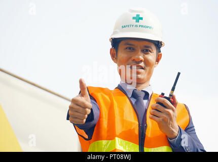 L'équipe de porter un casque et ingénieur radio utiliser la communication pour le contrôle des tâches de travail at construction site Banque D'Images