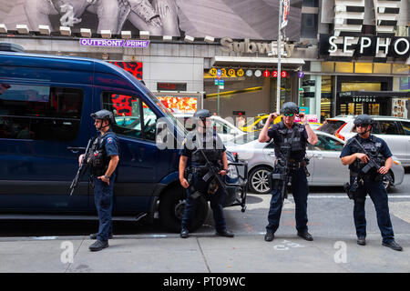 Quatre policiers de New York très armés dans la rue devant une station de métro de Times Square, faisant partie de la dissuasion terroriste de New York Banque D'Images