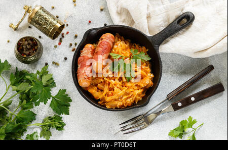 Compotée de chou avec carottes, oignons et tomates et saucisses au bacon avec le persil et les épices dans une poêle en fonte. Le Bigos. Délicieux déjeuner. F sélective Banque D'Images