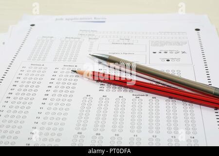 Photo de plusieurs feuilles d'examen, un crayon et un stylo. Isolé sur fond blanc. Banque D'Images