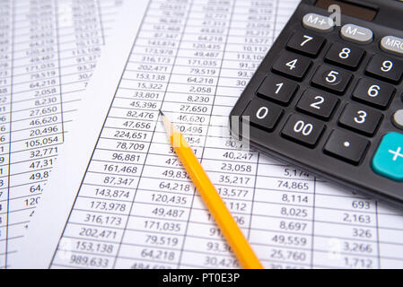 Plume d'affaires, calculatrice et verres sur tableau financier, concept d'entreprise. Banque D'Images