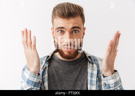 Portrait d'un jeune homme barbu confus looking at camera isolated over white Banque D'Images