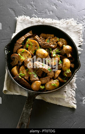 Bœuf stroganoff aux champignons dans une poêle à frire sur fond noir Banque D'Images