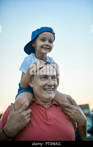 Portrait of happy petit garçon sur les épaules de son grand-père Banque D'Images