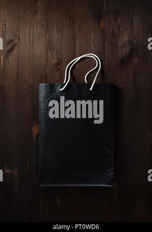Papier vide noir Panier avec poignées corde blanche sur fond de bois. Mise à plat. Banque D'Images
