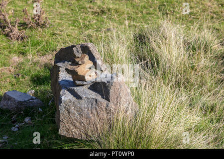 Quelqu'un a commencé une pile de pierres équilibré sur un gros rocher dans l'ancienne carrière fonctionnement sur Titterstone Clee Hill, London, UK Banque D'Images