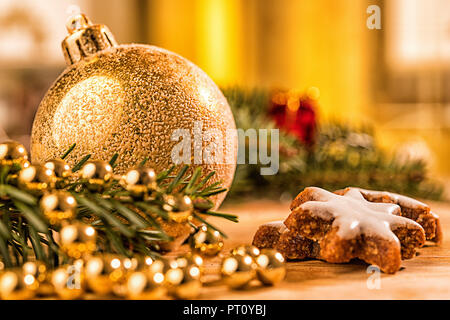 Goldene christbaumkugel mit Tannenzweig, Kerze, Lichter und Deko Banque D'Images