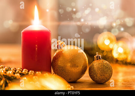 Goldene christbaumkugel mit Tannenzweig, Kerze, Lichter und Deko Banque D'Images