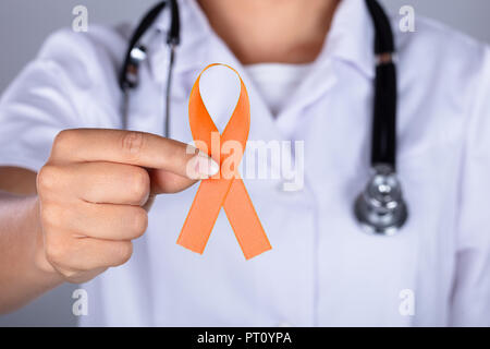 La main de femme médecin avec le ruban de la sensibilisation au cancer de l'utérus montrant Banque D'Images
