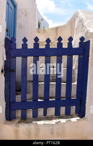 Grèce, l'île de Sikinos. Dans un coin de village, une porte en bois traditionnelle, simple est peinte en bleu profond. Banque D'Images