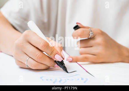 Pratiques par écrit l'étudiant calligraphe mot inspire avec marqueur vert sur toile. Artiste créateur indépendant travaillant sur projet au home studio. Lett Banque D'Images