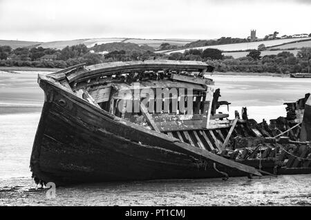 Partie d'une fracture ancienne coque de bateau en bois abandonnés sur la plage à pourrir. Banque D'Images
