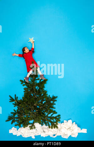 Girl decorating Christmas Tree Banque D'Images